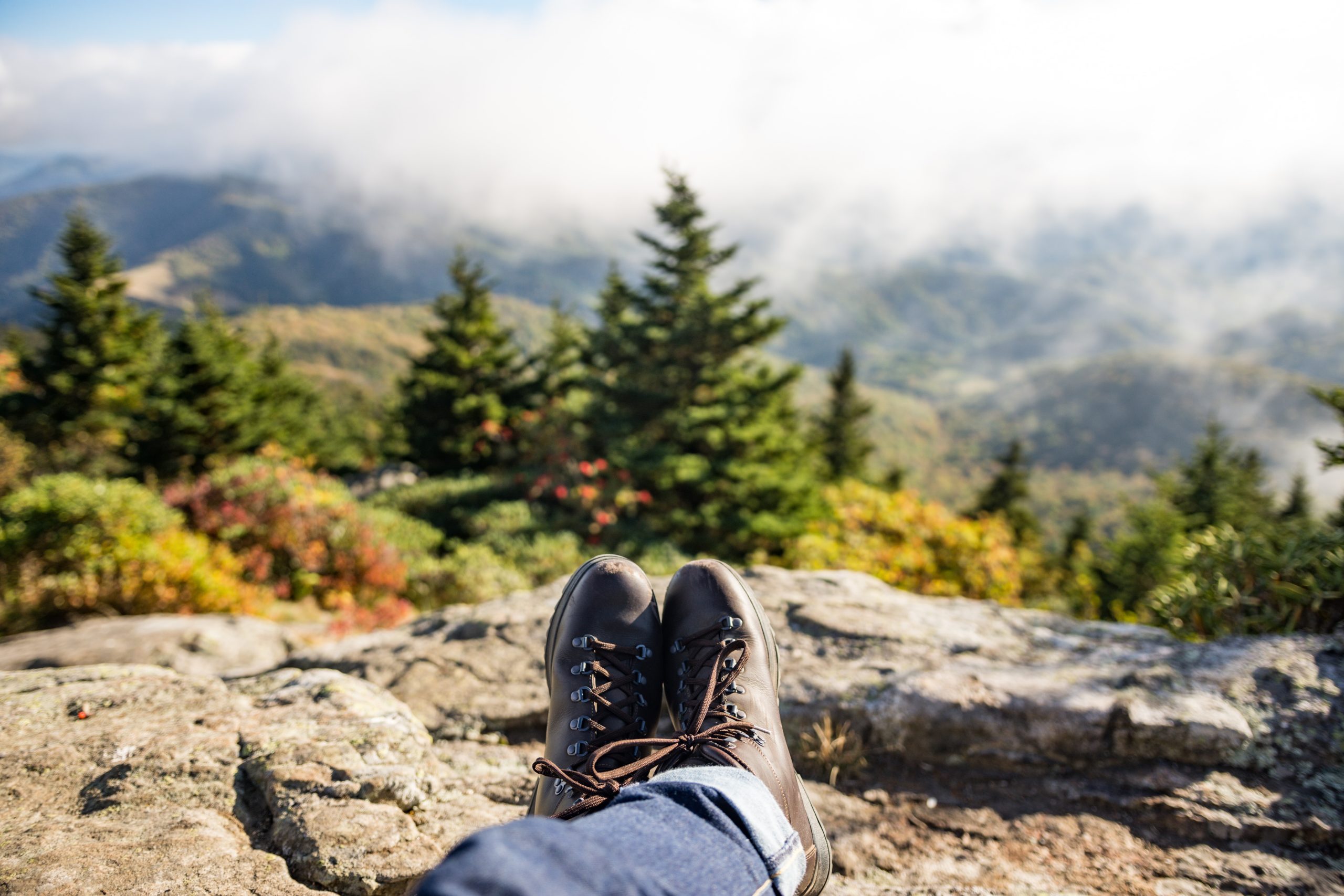 A person relaxes while overlooking a view on top of a hill.